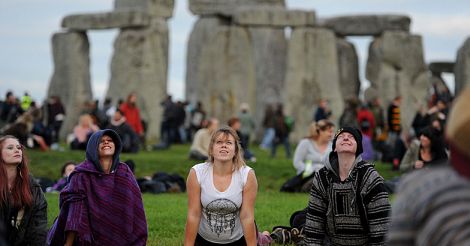 People perform yoga at Stonehenge