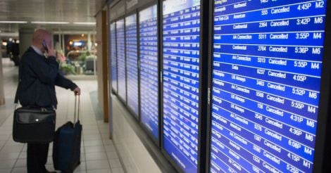 A traveller looks at an electronic flight board at the airport.