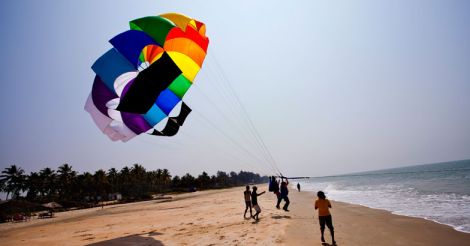 Tourists parasailing on a beach, North Goa, Goa, India Tourists parasailing on a beach, North Goa, Goa, India
