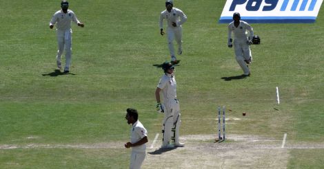 Bhuvneshwar Kumar (bottom) celebrates the wicket of Australia's captain Steve Smith (C) with teammates.