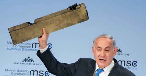 Israeli Prime Minister Benjamin Netanyahu holds up an object what he claimed was a piece of an Iranian drone shot down in Israeli airspace
