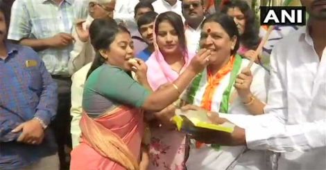 Congress members and workers celebrate outside party office in Bengaluru