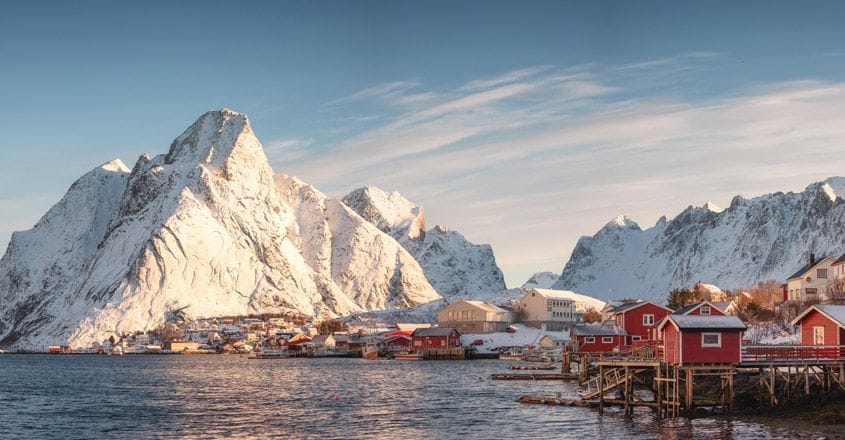 Scandinavian village with snow mountain at coastline in morning Scandinavian village with snow mountain at coastline in morning