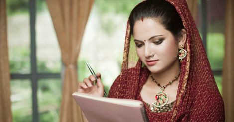 Happy newly married Indian, young woman reading on notepad.