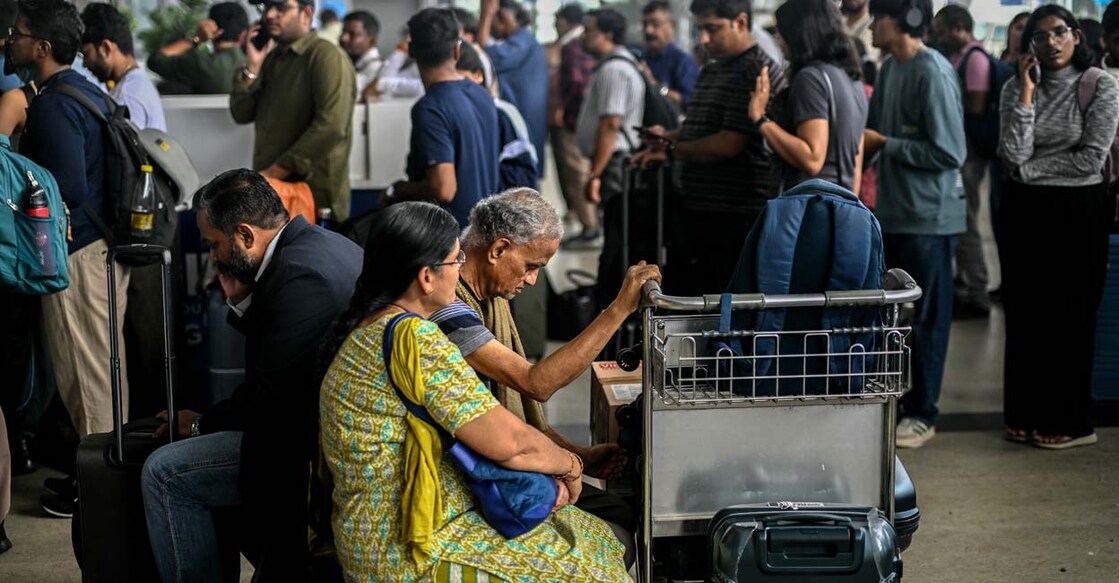 ഇൻഡിഗോ എയർലൈൻസിന്റെ സർവീസുകൾ റദ്ദാക്കിയതിനെത്തുടർന്ന് ചെന്നൈ രാജ്യാന്തര വിമാനത്താവളത്തിൽ കാത്തിരിക്കുന്നവർ.  (Photo by R.SATISH BABU / AFP)