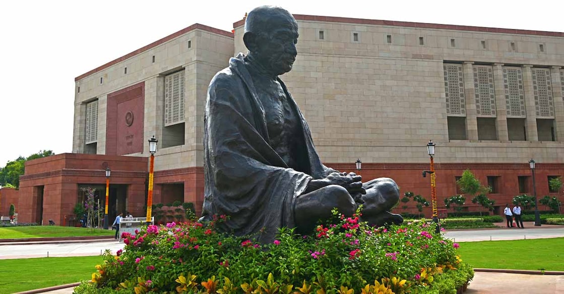 പുതിയ പാർലമെന്റ് മന്ദിരത്തിനോടു ചേർന്നുള്ള മഹാത്മാ ഗാന്ധിയുടെ പ്രതിമ (Photo by Money SHARMA / AFP)
