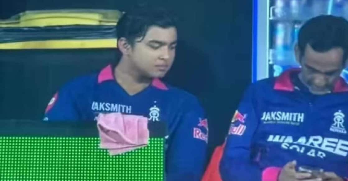 ആർസിബി– രാജസ്ഥാൻ മത്സരത്തിനിടെ ഡഗൗട്ടിലിരുന്ന ഫോൺ നോക്കുന്ന രാജസ്ഥാൻ ടീം മാനേജർ റോമി ഭിന്ദർ (വലത്). വൈഭവ് സൂര്യവംശി സമീപം. X/@ankanghosh335