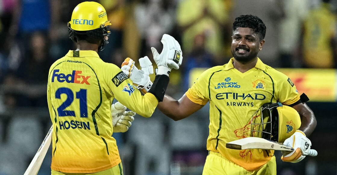 സെഞ്ചറി നേടിയ സഞ്ജു സാംസണെ അഭിനന്ദിക്കുന്ന അകീൽ ഹൊസെയ്ൻ (Photo by Punit PARANJPE / AFP)