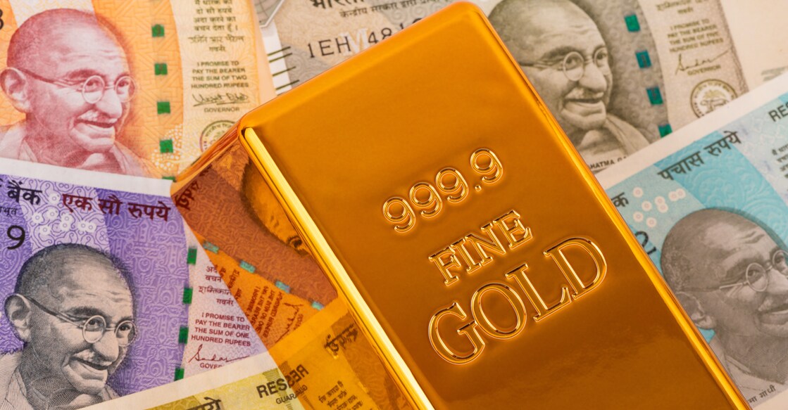 Indian rupee notes of different denominations of the Republic of India and a gold bar of 999 fineness