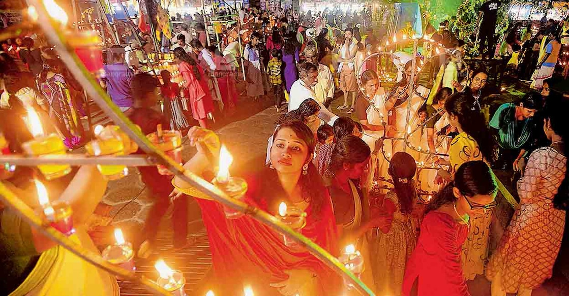 മണ്ണാറശാല നാഗരാജ ക്ഷേത്രത്തിലെ ദീപക്കാഴ്ചയ്ക്ക് ദീപം  കൊളുത്തുന്ന ഭക്തർ. ചിത്രം: മനോരമ  
