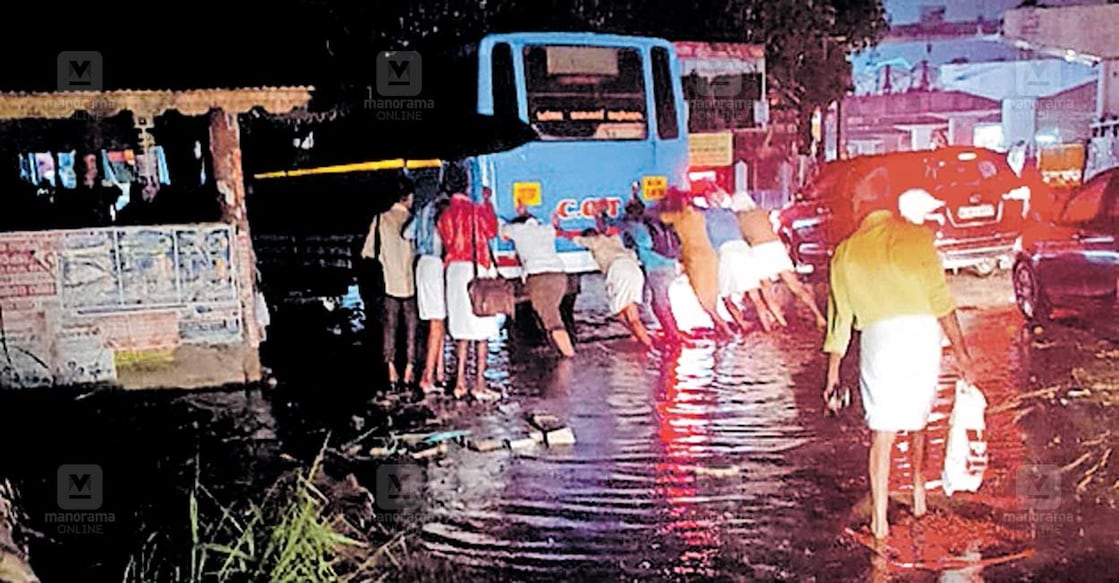 Thuravoor-road-flooding-disrupts ഇന്നലെ രാത്രിയുണ്ടായ മഴയിൽ അരൂർ–തുറവൂർ പാതയിലുണ്ടായ വെള്ളക്കെട്ടിൽ അകപ്പെട്ട് തകരാറിലായ സ്വകാര്യ ബസ് നാട്ടുകാർ ചേർന്നു തള്ളി മാറ്റുന്നു.
