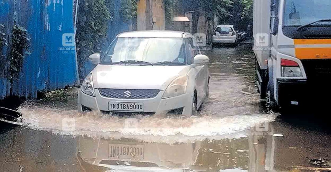 ശനിയാഴ്ച രാവിലെ പെയ്ത കനത്ത മഴയിൽ വെള്ളക്കെട്ടു രൂപപ്പെട്ട പുരുഷവാക്കത്തെ റോഡിലൂടെ നീങ്ങുന്ന വാഹനങ്ങൾ. 					ചിത്രം: മനോരമ  