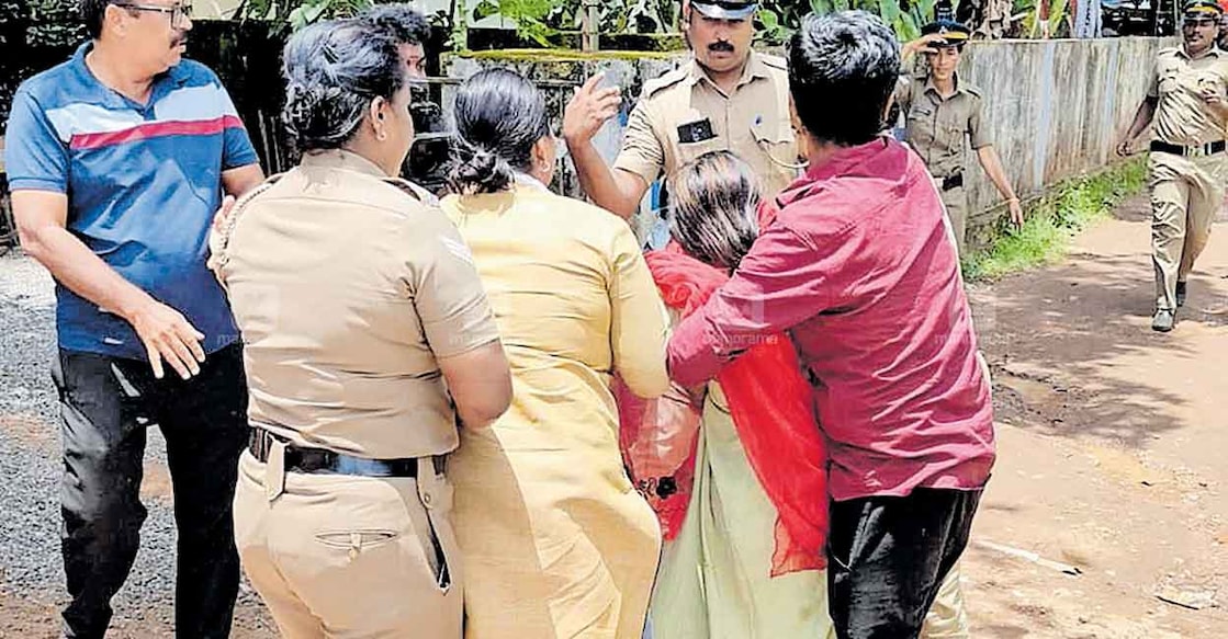  ആലുവയിൽ കൊല്ലപ്പെട്ട കുഞ്ഞിന്റെ അമ്മ ഇരുമ്പു പൈപ്പുമായി പ്രതിക്കു നേരെ പാഞ്ഞടുത്തപ്പോൾ പൊലീസും ഭർത്താവും ചേർന്നു പിടിച്ചുമാറ്റുന്നു