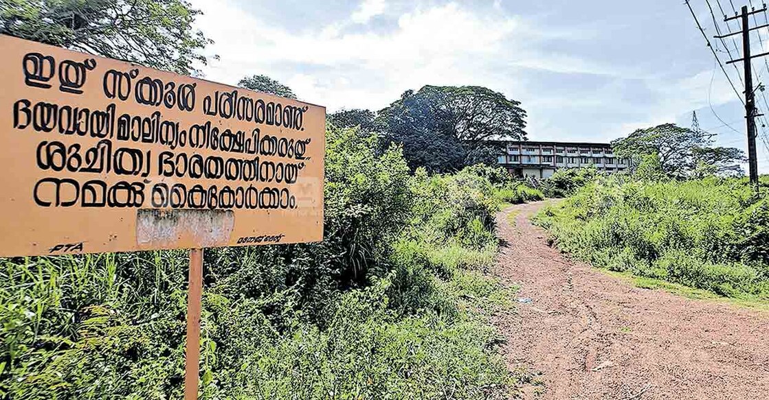 ചുറ്റും കുറ്റിച്ചെടികൾ നിറഞ്ഞ എച്ച്എംടി ഹൈസ്കൂൾ.   
