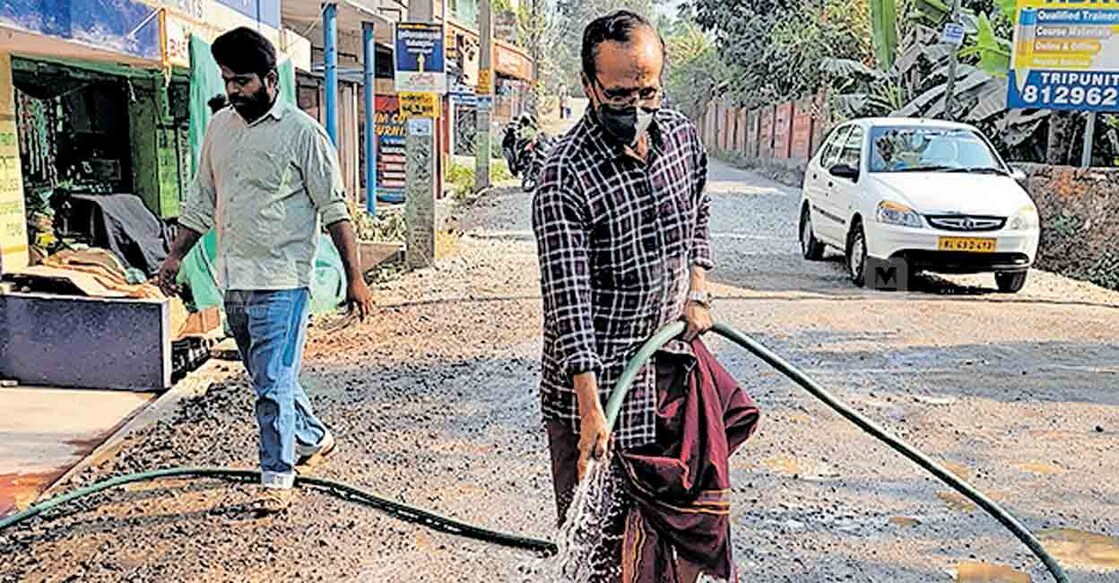 ചൂണ്ടി– രാമമംഗലം റോഡിലെ പൊടി ശല്യത്തിൽ നിന്നു രക്ഷ നേടാൻ വെള്ളം പമ്പു ചെയ്യുന്ന വ്യാപാരി.  