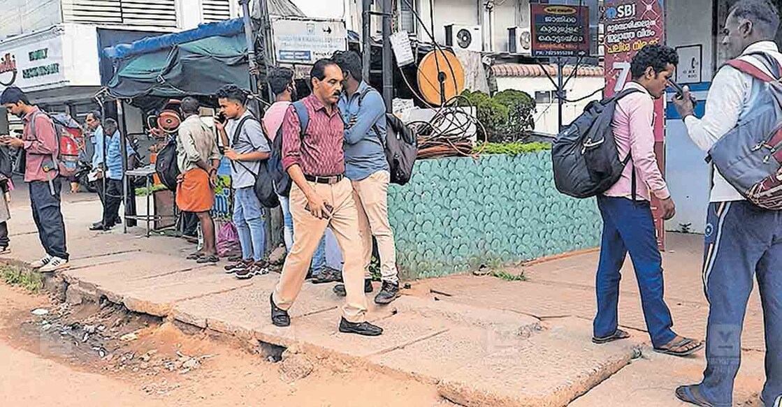 അങ്കമാലി നഗരസഭ പഴയ ഓഫിസിന് എതിർവശത്ത് എസ്ബിഐയ്ക്ക് മുന്നിൽ ബസ് കാത്തിരിപ്പുകേന്ദ്രം നീക്കം ചെയ്ത ഭാഗത്തു വെയിലത്ത് ബസ് കാത്തുനിൽക്കുന്ന യാത്രക്കാർ.