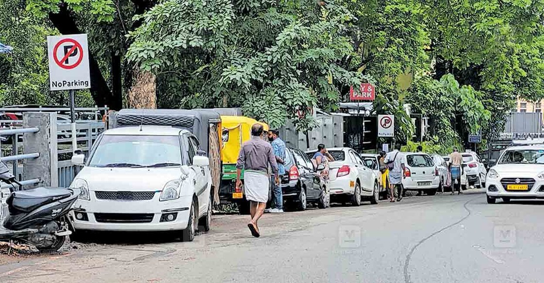 ആലുവ കെഎസ്ആർടിസി ബസ് സ്റ്റാൻഡിന്റെ എതിർവശത്തു 2 നോ പാർക്കിങ് ബോർഡുകൾക്കു താഴെ പാർക്ക് ചെയ്തിരിക്കുന്ന വാഹനങ്ങൾ.  