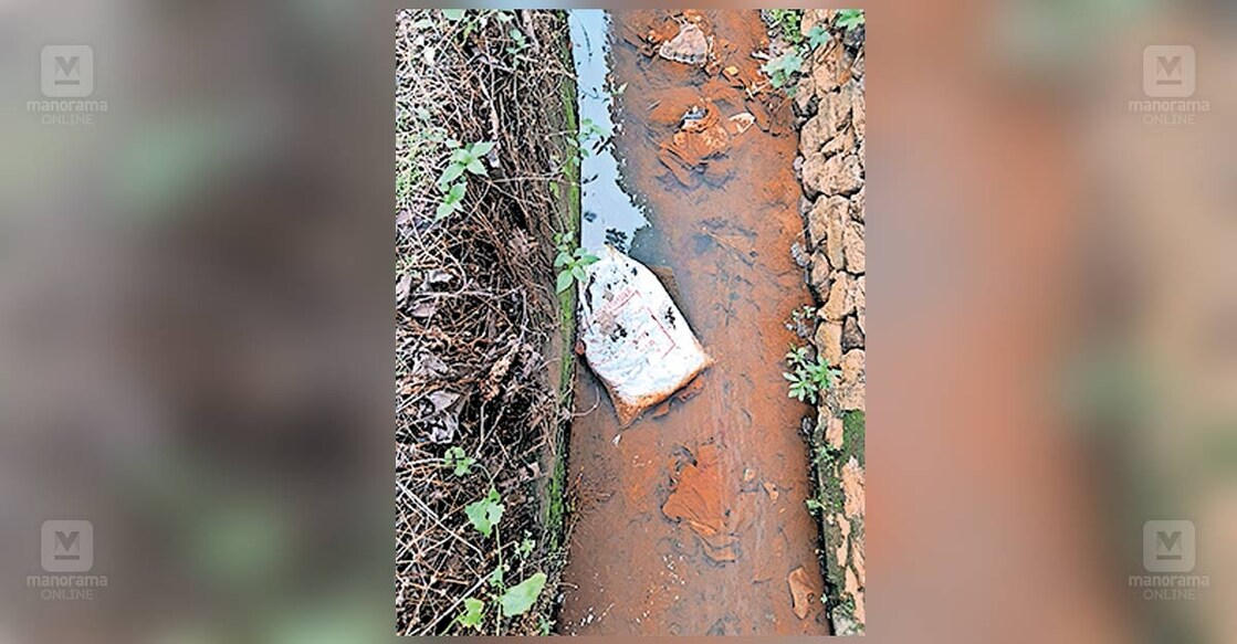 ബിഎസ്എൻഎൽ– കാംകോ റോഡിലെ തോട്ടിൽ ചാക്കിൽ കെട്ടി തള്ളിയിരിക്കുന്ന മാലിന്യം.  