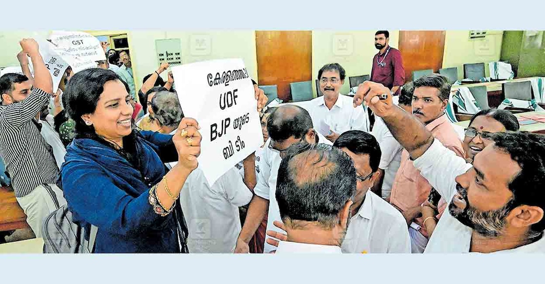 പറയാനുള്ളത് എഴുതിയിട്ടുണ്ട്..! പ്രാദേശിക സർക്കാരുകളുടെ തനത് ഫണ്ടുകൾ സ്പെഷൽ ട്രഷറി സേവിങ്സ് ബാങ്ക് അക്കൗണ്ടിലേക്കു മാറ്റണമെന്ന സർക്കാർ നിർദേശം അംഗീകരിക്കാത്ത കോർപറേഷൻ ഭരണസമിതിയുടെ നിലപാടിനെതിരെ കൗൺസിൽ യോഗത്തിൽ നടന്ന പ്രതിഷേധത്തിൽ പ്രതിപക്ഷ കൗൺസിലർ എസ്.ഷഹീദ ഭരണപക്ഷ കൗൺസിലർമാർക്ക് പ്ലക്കാർഡ് ഉയർത്തിക്കാണിക്കുന്നു.  ചിത്രം: മനോരമ