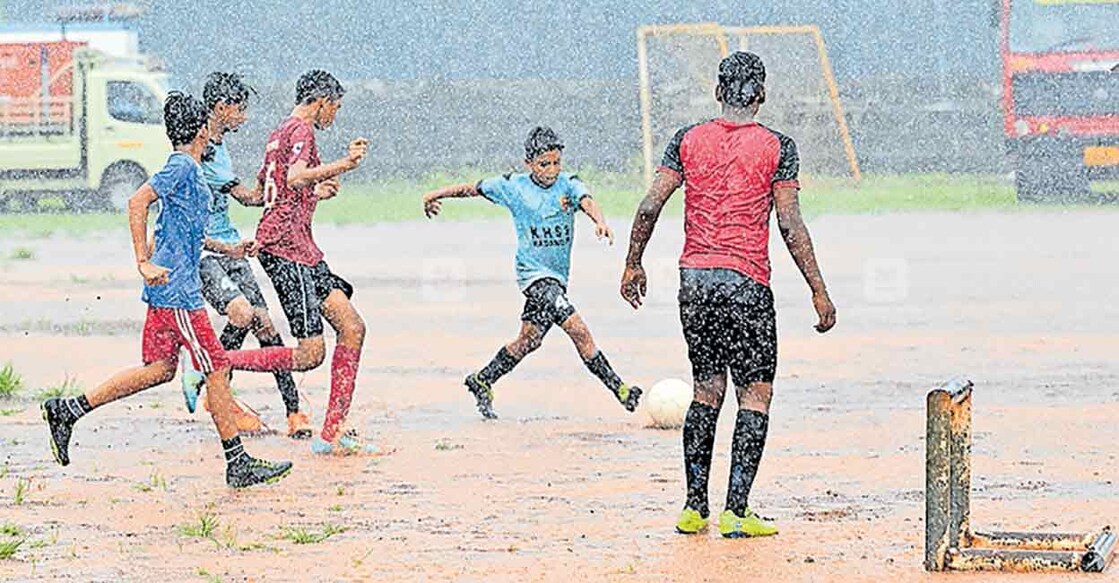 lack-of-rain-kasargod മഴയെ സൈഡ് ബെഞ്ചിലിരുത്താം..! ഒരിടവേളയ്ക്കു ശേഷം മഴ കനക്കുകയാണ്. കനത്ത മഴയിൽ മുഴപ്പിലങ്ങാട് കച്ചേരിമെട്ട സ്റ്റേഡിയത്തിൽ ഫുട്ബോൾ പരിശീലനത്തിലേർപ്പെട്ട കുട്ടികൾ ചിത്രം: മനോരമ