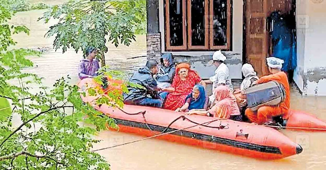 ഏറ്റുമാനൂർ മങ്കര കലുങ്ക് ഭാഗത്ത് വെള്ളക്കെട്ടിൽ കുടുങ്ങിയവരെ അഗ്നിരക്ഷാ സേന കരയ്ക്കെത്തിക്കുന്നു.  