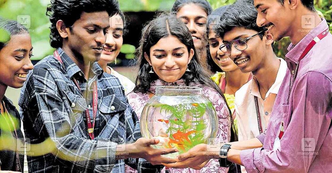 സിഎംഎസ് കോളജ് സുവോളജി വിഭാഗം ലാബിൽ വളർത്തുന്ന വിവിധയിനം അലങ്കാര മത്സ്യങ്ങളുമായി വിദ്യാർഥികൾ. ചിത്രം: മനോരമ  
