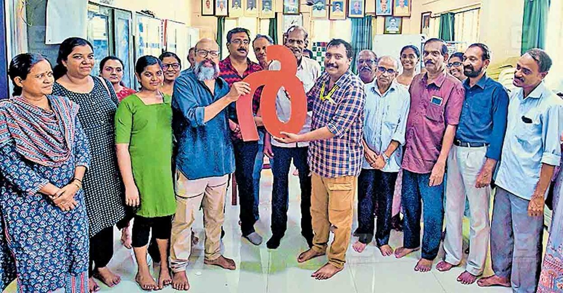 എരഞ്ഞിപ്പാലം വാഗ്ഭടാനന്ദ ഗുരുദേവർ സ്മാരക വായനശാലയിലെത്തിയ അക്ഷരപ്രയാണ സംഘത്തിനു നൽകിയ സ്വീകരണത്തിൽ വായനശാല പ്രസിഡന്റ് പി.എസ്.വിപിൻ മലബാറി ‘ആർ’ എന്ന അക്ഷരം മലയാള മനോരമ സീനിയർ റിപ്പോർട്ടർ വി.മിത്രനു കൈമാറുന്നു.  ചിത്രം: മനോരമ 