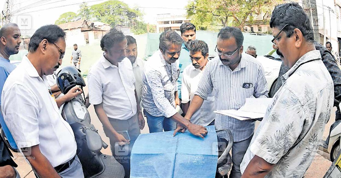 കല്ലായി പുഴയോരത്തെ പുറമ്പോക്ക് ഭൂമിയില്‍ കയ്യേറ്റം പരിശോധിക്കാനെത്തിയ പന്നിയങ്കര വില്ലേജ് ഓഫിസർ ഡി. കുമാറും കസബ വില്ലേജ് ഓഫിസർ വി.ജി.ശ്രീജിത്തും രേഖകൾ പരിശോധിക്കുന്നു. ചിത്രം: മനോരമ  
