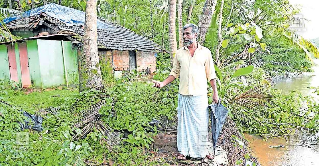 ശക്തമായ നീരൊഴുക്കിനെ തുടർന്ന് ഭീഷണി നേരിടുന്ന തന്റെ കുടുംബവീടിനു മുൻപിൽ പെരുന്തുരുത്തി പടിഞ്ഞാറേ പുഴവക്കത്ത് നസീർ. ചിത്രങ്ങൾ: മനോരമ  