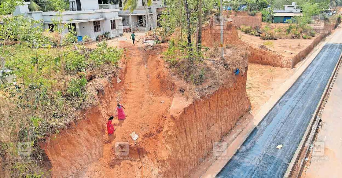 മലകയറ്റം... ആറുവരിപ്പാതയുടെ സർവീസ് റോഡിനായി കുഴിയെടുത്തതോടെ കുറ്റിപ്പുറം മിനിപമ്പയ്ക്കു സമീപം ഒറ്റപ്പെട്ട വീടുകൾ. റോഡിൽനിന്ന് വീട്ടിലേക്ക് കയാറാൻ ശ്രമിക്കുന്ന സ്ത്രീകളെയും കാണാം.  
