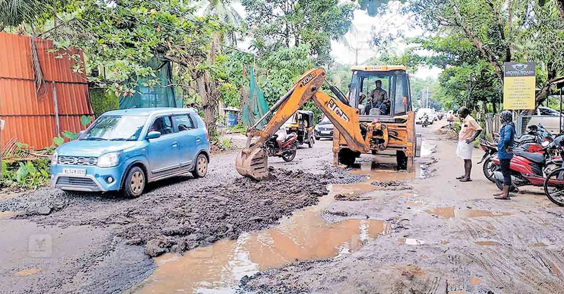 തകർന്നു കിടക്കുന്ന പൊന്നാനി–ഗുരുവായൂർ സംസ്ഥാനപാതയിലെ എരമംഗലം താഴത്തേൽപടിയിൽ മണ്ണുമാന്തി ഉപയോഗിച്ച് റോഡിലെ കുഴികൾ അടയ്ക്കുന്നു.  