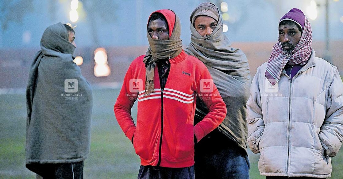 new-delhi-red-alert കടുത്ത തണുപ്പിൽ നിന്ന് രക്ഷ നേടുന്നതിനായി മൂടിപ്പുതച്ച് നിൽക്കുന്നവർ. ഓൾഡ് ഡൽഹിയിൽ നിന്നുള്ള കാഴ്ച. ചിത്രം : മനോരമ