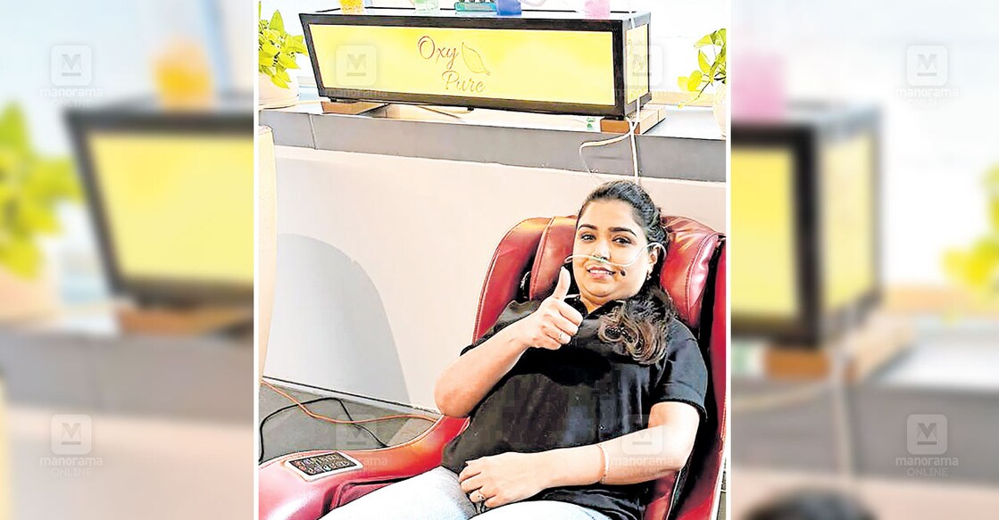 എയർപോർട്ടിലെ ‘ഓക്സി പ്യുർ’ ഓക്സിജൻ ബാറിൽ നിന്ന് ശുദ്ധമായ ഓക്സിജൻ ശ്വസിക്കുന്ന യുവതി.  
