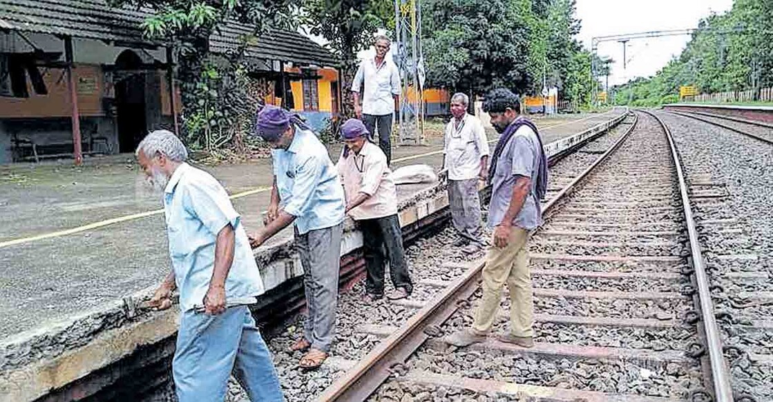 Palakkad News മങ്കര റെയിൽവേ സ്റ്റേഷനിൽ ഡബിൾ ഡെക്കർ ട്രെയിൻ പോകാനായി പ്ലാറ്റ്ഫോമിന്റെ അരിക് വെട്ടിയൊതുക്കുന്ന ജീവനക്കാർ.