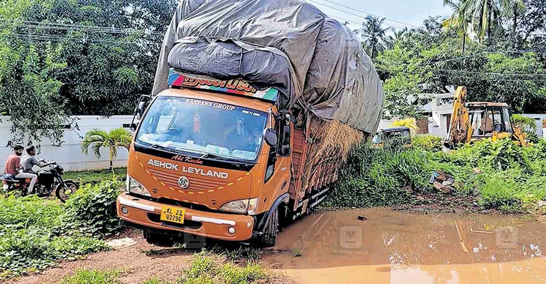 കോട്ടപ്പള്ള – പൊൻപാറ റോഡരികിലെ ചെളിയിൽ കുടുങ്ങിയ ലോറി ജെസിബി ഉപയോഗിച്ചു വലിച്ചു കയറ്റാനുള്ള തയാറെടുപ്പ്.  
