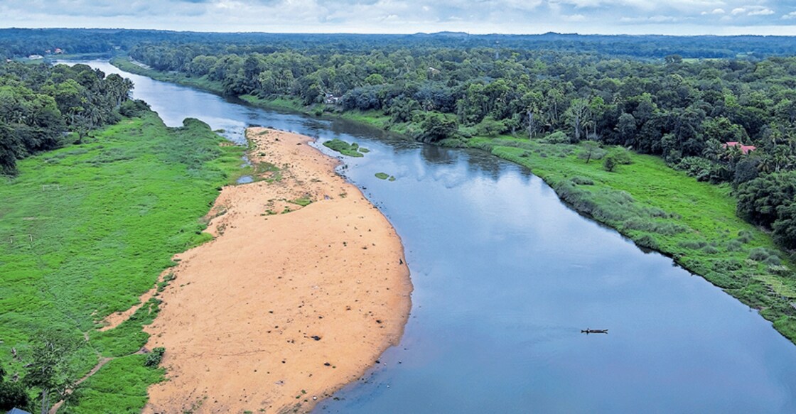 pathanamthitta-river പ്രതീക്ഷയുടെ നദിപ്പച്ചയ്ക്കു മേൽ ആശങ്കയുടെ ഇരുൾവാനം...
അന്നു പ്രളയം കുലംകുത്തി പാഞ്ഞത് ഈ നെട്ടായം കടന്നാണ്. നദി അതിന്റെ ‘ജീവനായി’ കരുതിയ ജൈവ സാന്നിധ്യങ്ങളും ആ യാത്രയിൽ കൂടെച്ചേർന്നു. ജീവൻ പോയ ശരീരത്തിൽ ബാക്കി വന്ന അസ്ഥിപഞ്ജരം കണക്കെ വെളുത്ത മണൽശേഖരങ്ങൾ നദിയുടെ മാറിൽ ഒരോർമചിത്രം പോലെ ബാക്കിയായി. കരയിൽ നിന്ന് ഊർന്നിറങ്ങുന്ന പച്ചപ്പുകൾ ജൈവ നാമ്പുകളുടെ മടങ്ങി വരവറിയിച്ച് മൺകൂനകളെ തൊട്ടു വളരുമ്പോൾ മുകളിൽ ആധിയുടെ മേഘച്ചുഴിയിൽ വീണ്ടുമൊരു മഴക്കാലം ഒളിച്ചുനിൽക്കുന്നു. ഇന്ന് ലോക ജൈവ വൈവിധ്യദിനം. ആറന്മുള മല്ലപ്പുഴശേരി മരുതൂർ കടവിൽ നിന്ന്. ചിത്രം: അരവിന്ദ് വേണുഗോപാൽ ∙ മനോരമ
