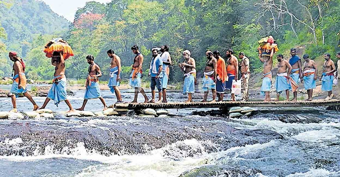 തിരുവാഭരണം വഹിച്ചുകൊണ്ടുള്ള ഘോഷയാത്ര അട്ടത്തോട് കൊല്ലമൂഴിയിൽ പമ്പാനദി മുറിച്ച് കടന്ന് ശബരിമലയിലേക്ക് നീങ്ങുന്നു.                                                                           ചിത്രം: മനോരമ  
