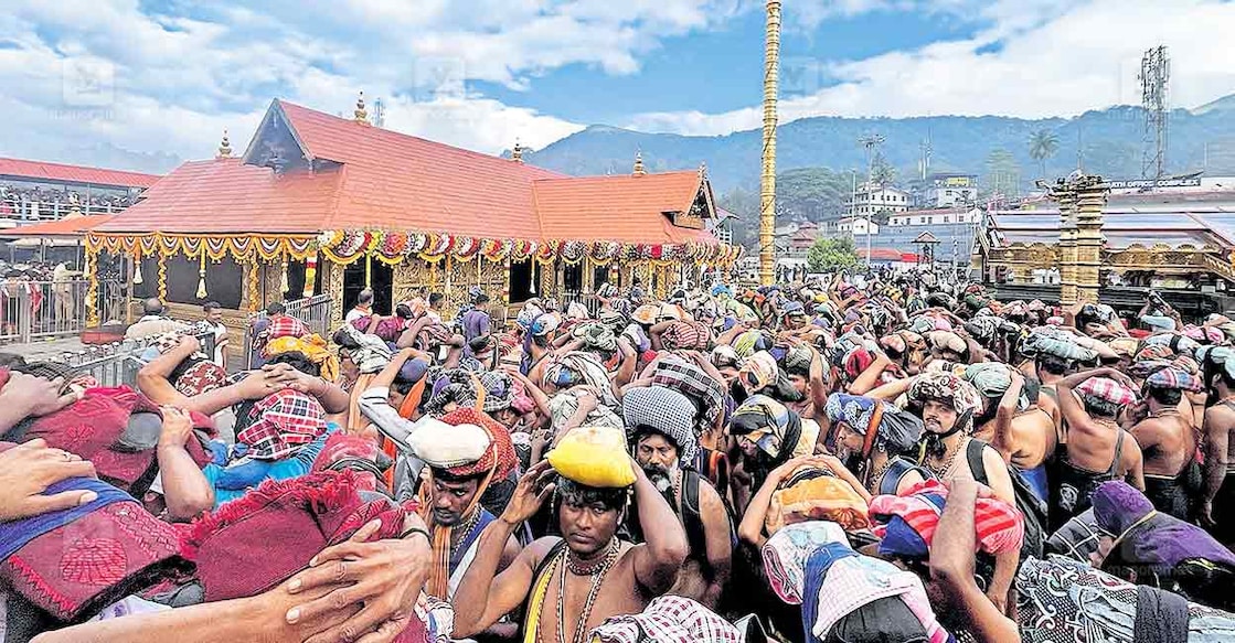 ദേവമാശ്രയേ: നാവിൽ ശരണമന്ത്രവും മനസ്സിൽ അയ്യപ്പ രൂപവുമായി വൃശ്ചിക പുലരിയിൽ ദർശനം തേടി ശബരിമല സന്നിധാനത്ത് എത്തിയ തീർഥാടകരുടെ തിരക്ക്. വൃശ്ചികം പിറന്നതിന്റെ സന്തോഷമായി ക്ഷേത്രം പൂക്കൾ കൊണ്ട് അലങ്കരിച്ചതും കാണാം. ചിത്രം: മനോരമ  