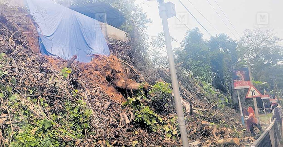 പൂവമ്പാറ റെസ്റ്റ് ഹൗസിന്റെ മതിലിനോട് ചേർന്ന് ദേശീയപാതയോരത്തെ മണ്ണിടി‍ഞ്ഞ ഭാഗത്ത് ടാർപ്പോളിൻ ഉപയോഗിച്ച് മൂടിയിരിക്കുന്നു. രണ്ടാഴ്ച മുൻപ് കടപുഴകി വീണ വൻ മരത്തിന്റെ അവശിഷ്ടങ്ങളും 

കാണാം  


