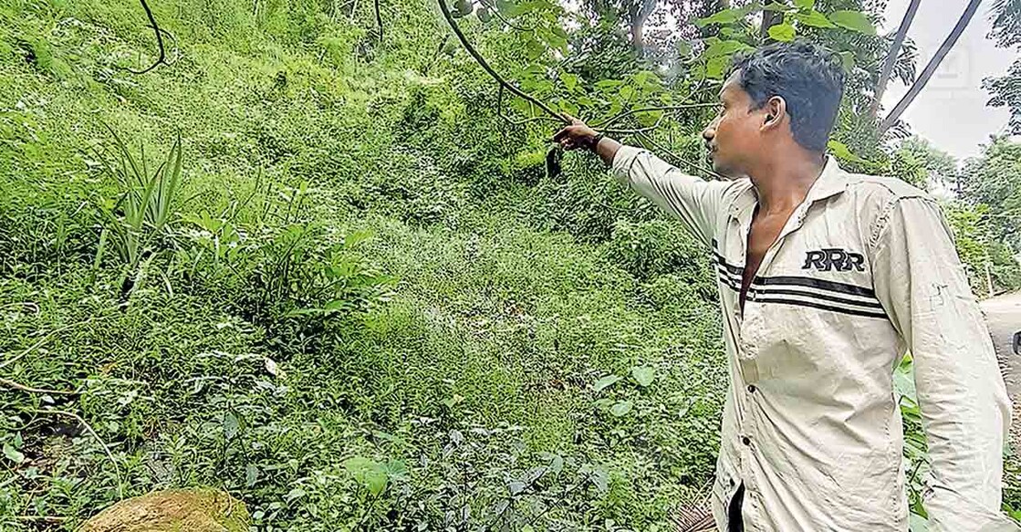 സുമേഷ് തന്റെ വീടിനോട് ചേർന്ന്  ഉരുൾപൊട്ടിയ സ്ഥലം ചൂണ്ടിക്കാണിക്കുന്നു. ചിത്രങ്ങൾ: ആർ.എസ്.ഗോപൻ/മനോരമ  
