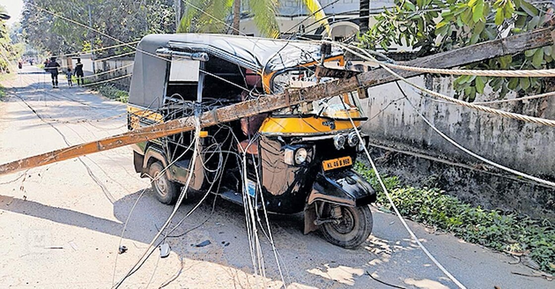 guruvayur-accident ചൊവ്വല്ലൂർപടിയിൽ മരം വീണ് തകർന്ന വൈദ്യുത പോസ്റ്റുകൾക്കടിയിൽ കുടുങ്ങിയ ചൊവ്വല്ലൂർ രാമനാത്ത് ഷാഹുവിന്റെ ഓട്ടോറിക്ഷ.