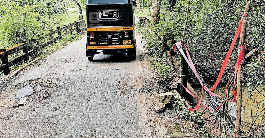 bridge-road-destroy കോളേരി പാലത്തിന്റെ കൈവരികളും സുരക്ഷാഭിത്തിയും തകർന്നതോടെ യാത്രക്കാർ പുഴയിൽ വീഴാതിരിക്കാൻ നാട്ടുകാർ റിബൺ കെട്ടി മുന്നറിയിപ്പ് നൽകിയിരിക്കുന്നു.