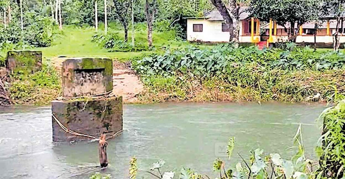 ശക്തമായ മഴയിൽ പുഴയിൽ നീരൊഴുക്ക് വർധിച്ചതിനെത്തുടർന്നു കുഞ്ഞോം ഭഗവതിക്കാവ് ക്ഷേത്രത്തിലേക്കുള്ള പാലം ഒലിച്ചു പോയ നിലയിൽ.  