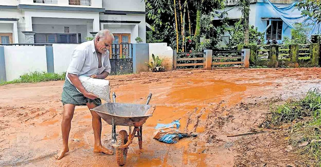 കണിയാമ്പറ്റ പഞ്ചായത്തിലെ മൃഗാശുപത്രി കവല - കൊല്ലിവയൽ റോഡിലൂടെ ഉന്തുവണ്ടിയിൽ സാധനങ്ങൾ കൊണ്ടുവരുന്നതിനിടെ, മറിഞ്ഞ് നിലത്തു വീണ സാധനങ്ങൾ ചെളി നിറഞ്ഞ റോഡിൽ നിന്ന് ഉന്തുവണ്ടിയിൽ കയറ്റുന്ന കർഷകൻ.  