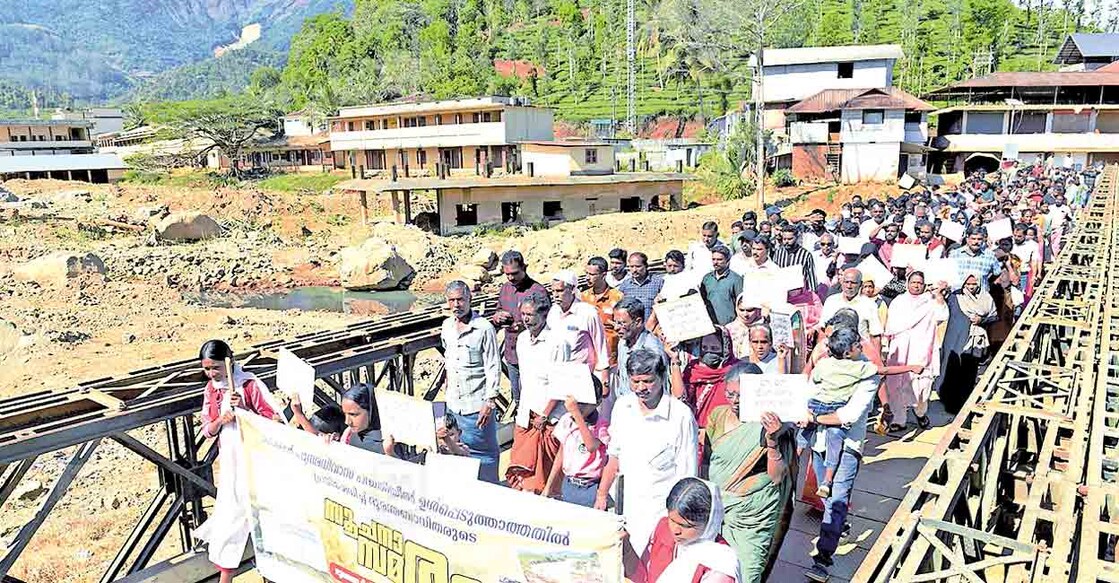 സർക്കാരിന്റെ പുനരധിവാസ പദ്ധതിയിൽ ഉൾപ്പെടുത്താത്തതിൽ പ്രതിഷേധിച്ച് ചൂരൽമല സ്കൂൾ റോഡ്, പടവെട്ടിക്കുന്ന് എന്നീ പ്രദേശങ്ങളിലെ ദുരന്തബാധിതർ ബെയ്‌ലി പാലത്തിലൂടെ നടത്തിയ പ്രകടനം. ചിത്രം: മനോരമ  
