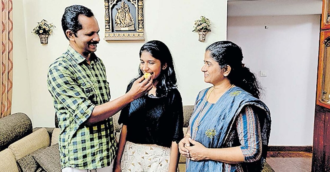 മുഴുവൻ മാർക്കും നേടിയ നേഹയ്ക്ക് മധുരം നൽകുന്ന പിതാവ് വി.പി.വിനോദ്കുമാർ. മാതാവ് സീനാമോൾ സമീപം. 