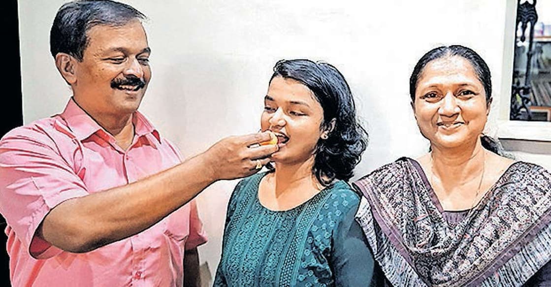 civil-services-examination-2024-topper-reenu-anna-mathew റീനു അന്ന മാത്യുവിന് അച്ഛൻ ജോജി മാത്യു ജോർജ് മധുരം നൽകുന്നു.