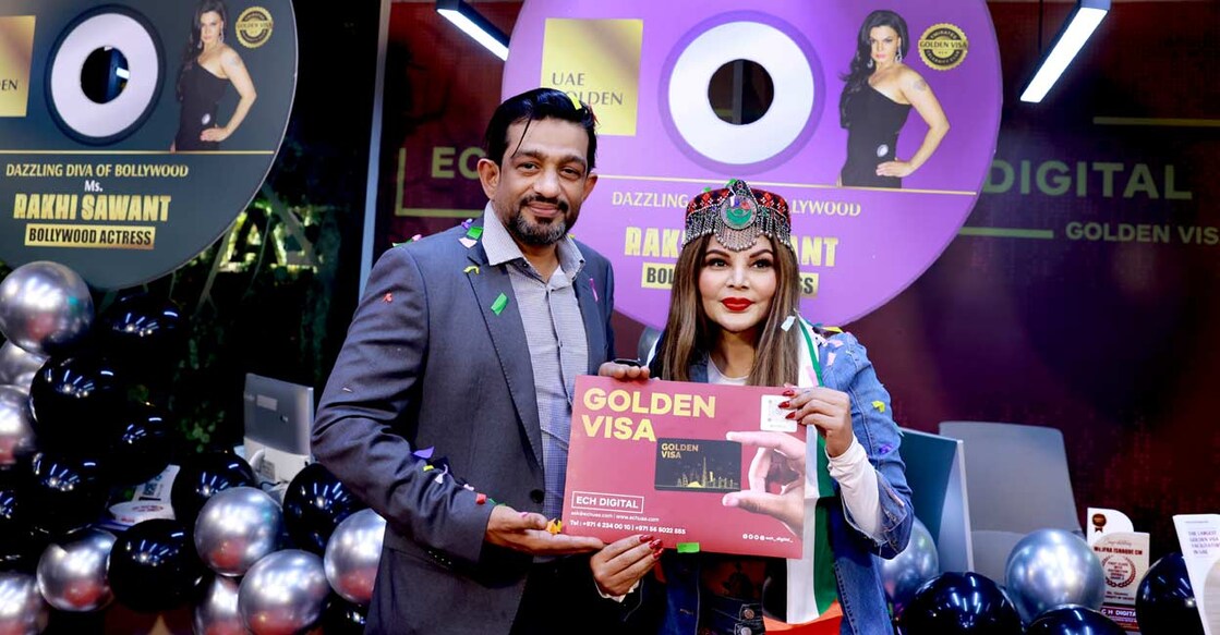 uae-golden-visa-rakhi-sawant ഇസിഎച്ച് ഡിജിറ്റലിൽ സിഇഒ ഇഖ്ബാൽ മാർക്കോണിയിൽ നിന്നു രാഖീ സാവന്ത് യുഎഇ ഗോൾഡൻ വീസ ഏറ്റുവാങ്ങിയപ്പോൾ