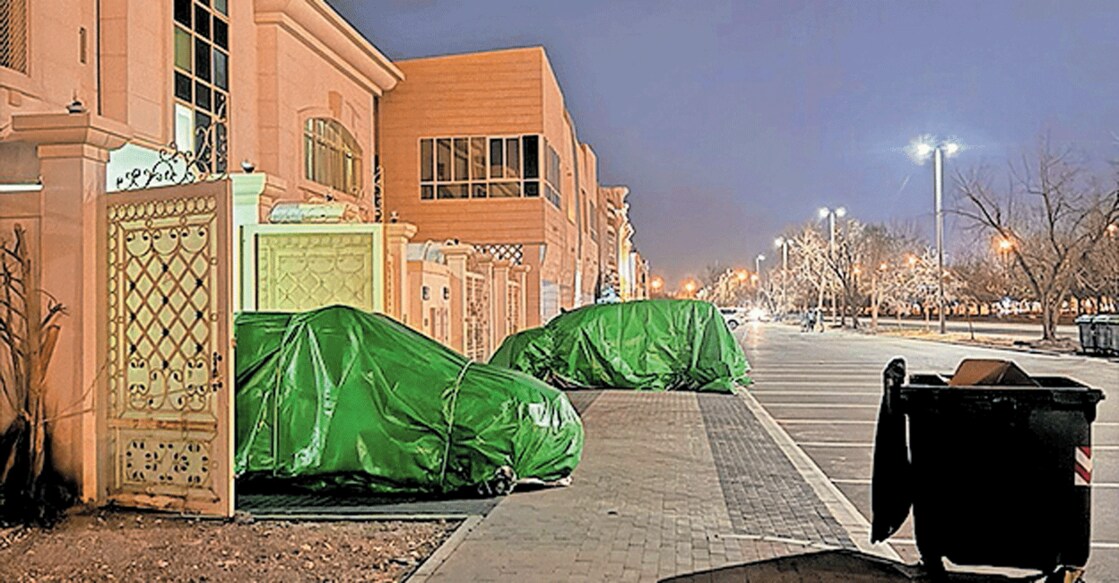 uae-with-rain-hail-forecast-al-ain-residents-shield-cars-with-cardboard-yoga-mats ആലിപ്പഴത്തിൽ നിന്ന് വാഹനം സംരക്ഷിക്കുന്നതിന്റെ ഭാഗമായി തുണിയും കാർഡ്ബോർഡും മെത്തയും ഉപയോഗിച്ചു കാർ മൂടിയ നിലയിൽ.