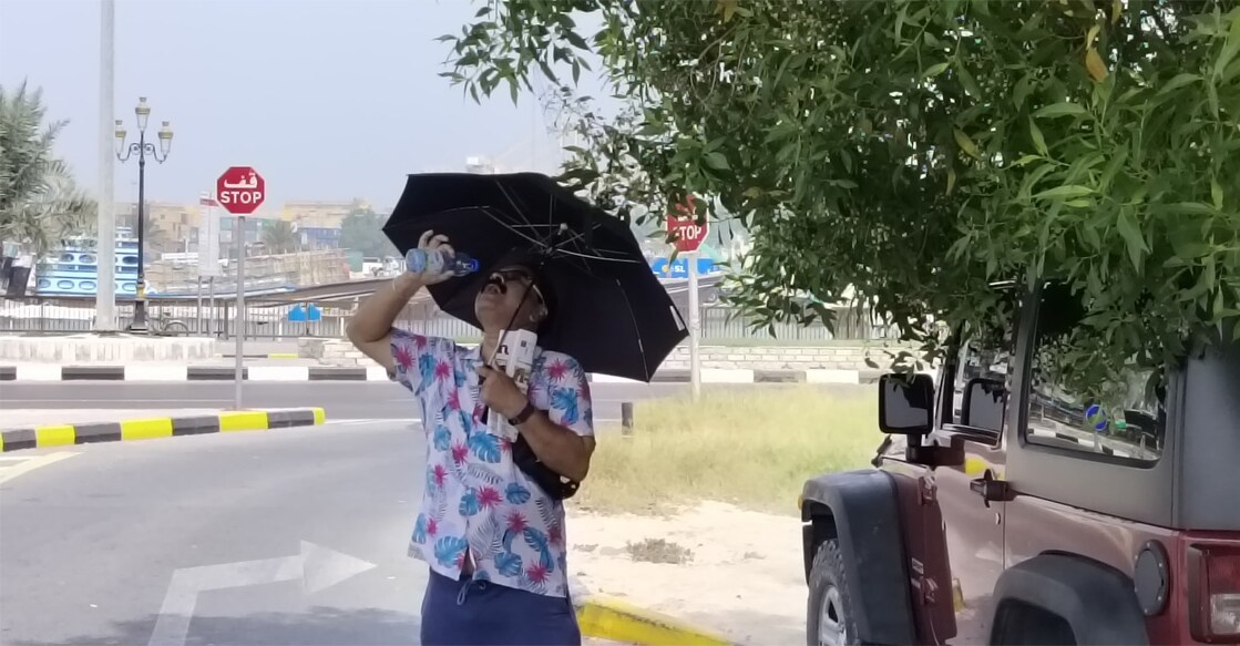 ഷാർജ അൽ ജുബൈലിൽ മരത്തണലില്‍ നിന്ന് വെള്ളം കുടിക്കുന്ന മലയാളി. ചിത്രം: സിറാജ് വി.പി.കീഴ്മാടം